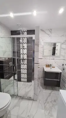 a bathroom with a shower and a sink and a toilet at Apartament DeLuxe 2 in Oświęcim