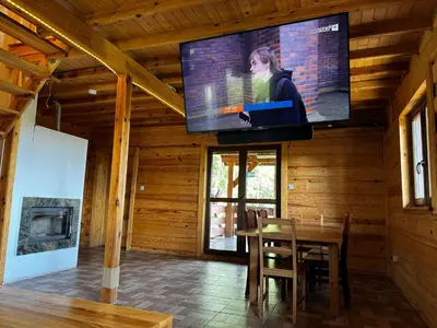 a living room with a tv in a wooden house at Ranczo Targoszów in Targoszów