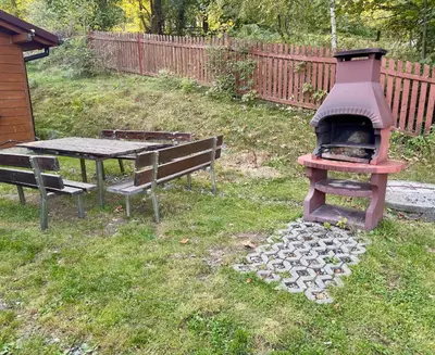 a grill and a picnic table and a table and bench at Ranczo Targoszów in Targoszów
