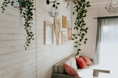 a living room with a couch and plants on the wall at Domki Beskidowelove Gierałtowiczki A in Zator