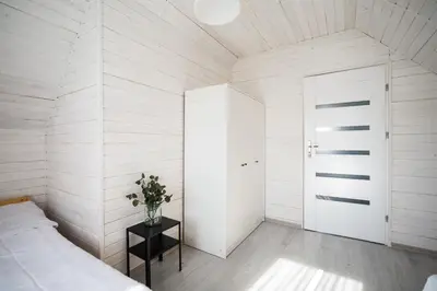 a bedroom with white walls and a bed and a door at Domki Beskidowelove Gierałtowiczki A in Zator