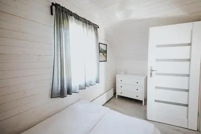 a small bedroom with a bed and a window at Domki Beskidowelove Gierałtowiczki A in Zator