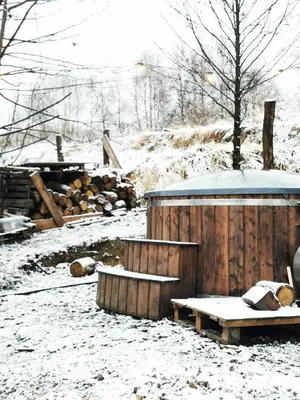 a snow covered yard with a wooden shed and a bench at LushHills - Stylowa i Naturalna Jurta in Regulice