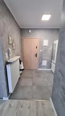 a room with a wooden door and a room with a desk at Apartament DeLuxe 3 in Oświęcim