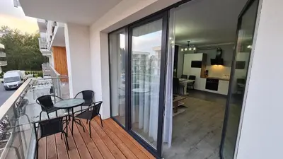 a balcony with a table and chairs on a deck at Apartament DeLuxe 3 in Oświęcim