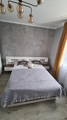a bedroom with a large bed with a stone wall at Apartament DeLuxe 3 in Oświęcim
