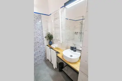 a bathroom with a white sink and a shower at Rose - Apartamenty Kleparskie in Kraków