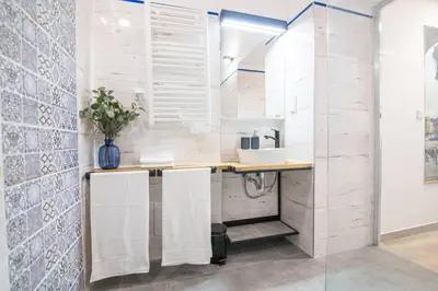 a bathroom with a sink and a counter with towels at Rose - Apartamenty Kleparskie in Kraków