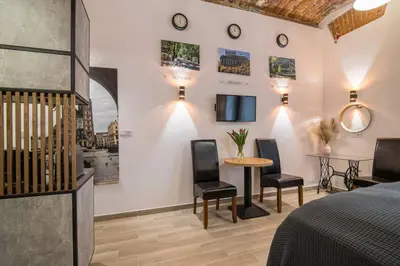a bedroom with a bed and a table and chairs at Rose - Apartamenty Kleparskie in Kraków