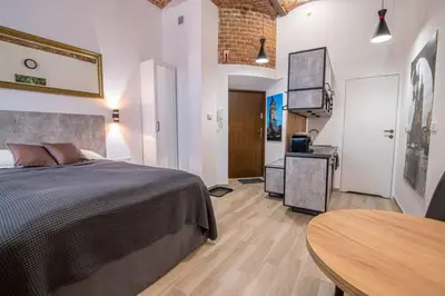 a bedroom with a bed and a table in it at Rose - Apartamenty Kleparskie in Kraków