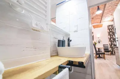 a bathroom with a sink on a wooden counter at Rose - Apartamenty Kleparskie in Kraków