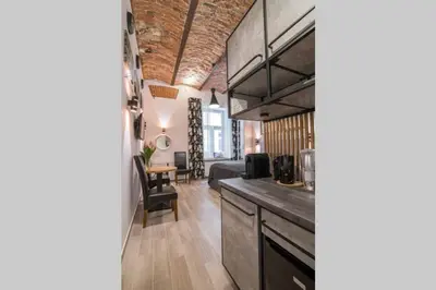 a room with a kitchen and a living room at Rose - Apartamenty Kleparskie in Kraków