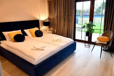 a bedroom with a large bed with a large window at Apartamenty na Dworskiej - BLISKO ENERGYLANDIA ZATORLAND in Spytkowice