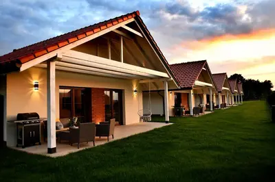 a row of houses with chairs and a lawn at Apartamenty na Dworskiej - BLISKO ENERGYLANDIA ZATORLAND in Spytkowice