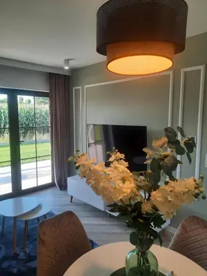 a living room with a vase of flowers on a table at Apartamenty na Dworskiej - BLISKO ENERGYLANDIA ZATORLAND in Spytkowice