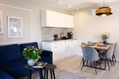 a kitchen and living room with a blue couch and a table at Apartamenty na Dworskiej - BLISKO ENERGYLANDIA ZATORLAND in Spytkowice
