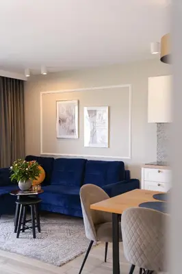 a living room with a blue couch and a table at Apartamenty na Dworskiej - BLISKO ENERGYLANDIA ZATORLAND in Spytkowice