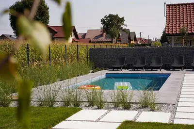a swimming pool in a yard with chairs around it at Apartamenty na Dworskiej - BLISKO ENERGYLANDIA ZATORLAND in Spytkowice