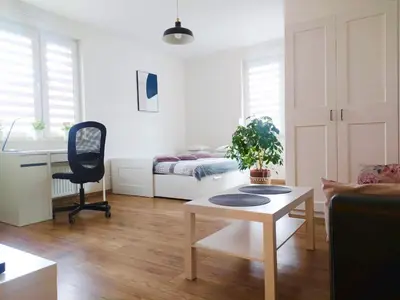 a living room with a table and a desk at Apartament Łagiewniki in Kraków