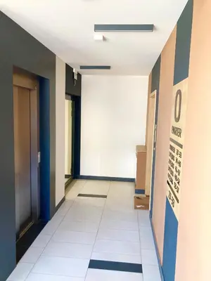 a hallway of an office building with a white tile floor at Apartament Łagiewniki in Kraków