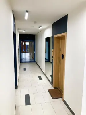 a corridor of an office building with a hallway at Apartament Łagiewniki in Kraków