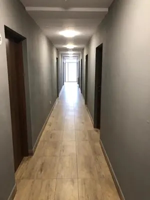 an empty hallway with a long hallway with a hallwayngth at Aparthotel WADOWICE & Hostel GENERY in Wadowice