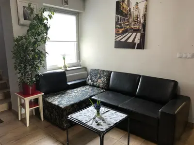 a living room with a black couch and a table at Aparthotel WADOWICE & Hostel GENERY in Wadowice