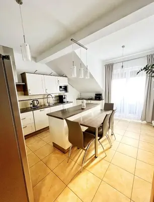 a kitchen with a table and chairs in a kitchen at Apartament Premium Skawina in Skawina