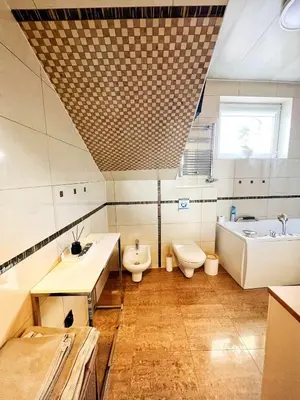 a bathroom with two toilets and a tub and a sink at Apartament Premium Skawina in Skawina