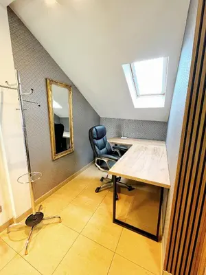 an attic office with a desk and a mirror at Apartament Premium Skawina in Skawina
