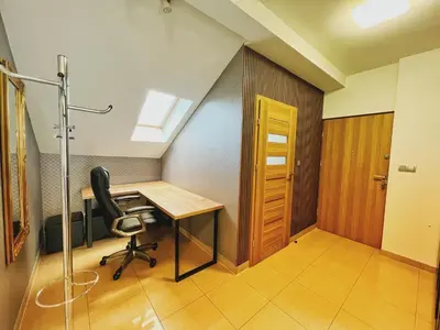 an attic office with a desk and a chair at Apartament Premium Skawina in Skawina