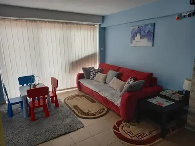 a living room with a red couch and a table at Ojcowski Las in Biały Kościół