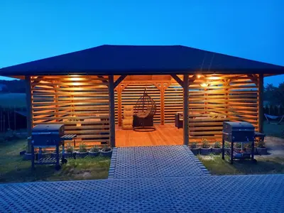 a wooden gazebo with a table and two chairs at Ojcowski Las in Biały Kościół