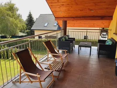 a patio with two rocking chairs and a table at Ojcowski Las in Biały Kościół