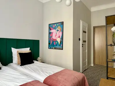 a bedroom with a bed and a painting on the wall at Milla Apartments in Kraków
