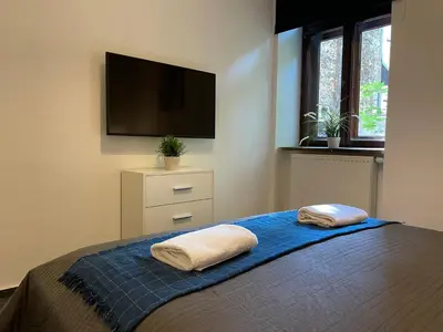 a bedroom with a bed with two pillows on it at Milla Apartments in Kraków