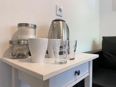 a table with cups and a blender and glasses on it at Milla Apartments in Kraków