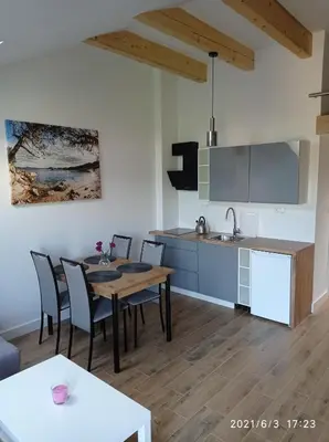 a kitchen and dining room with a table and chairs at Apartamenty Kasztanowa Zator in Zator