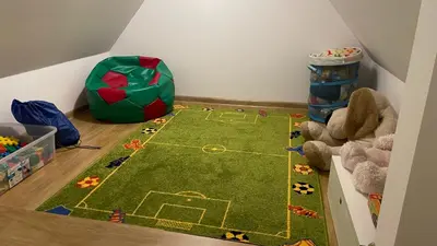a green rug with a soccer field on the floor in a room at Domek Damianki - cały dom in Zawoja