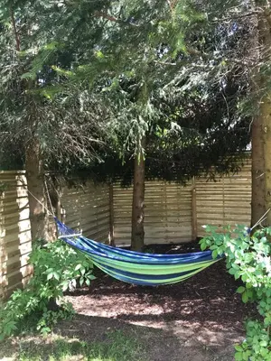 a blue hammock in a yard under a tree at Domek Damianki - cały dom in Zawoja