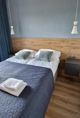 a bedroom with a bed with two pillows on it at Apartamenty Parkowe D9 z garażem in Oświęcim