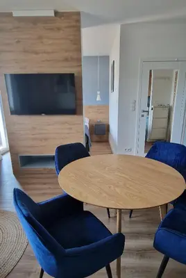 a living room with a table and chairs and a television at Apartamenty Parkowe D9 z garażem in Oświęcim