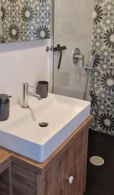 a bathroom with a white sink and a shower at Apartamenty Parkowe D9 z garażem in Oświęcim