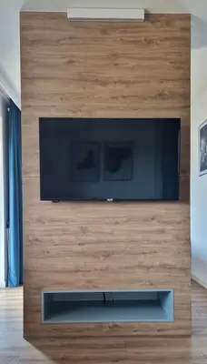 a flat screen tv on a wooden wall in a living room at Apartamenty Parkowe D9 z garażem in Oświęcim