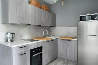 a kitchen with stainless steel cabinets and a refrigerator at Barska 69 Taras 360 in Kraków