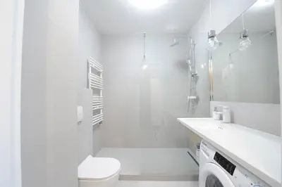 a white bathroom with a toilet and a shower at Barska 69 Taras 360 in Kraków