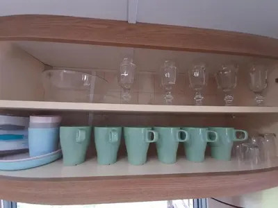 a row of cups and wine glasses on a shelf at Gosp. Agroturystyczne Stary Gaj in Żerkowice