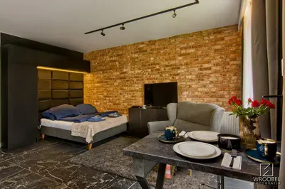 a living room with a bed and a table at Jacuzzi Rakowicka Top Apartments in Kraków