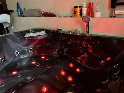 a black bath tub with red lights in a bathroom at Jacuzzi Rakowicka Top Apartments in Kraków