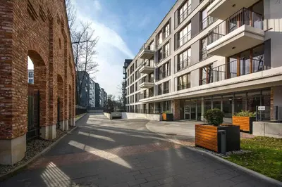 an empty street next to a brick building at Jacuzzi Rakowicka Top Apartments in Kraków